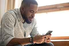 Black male looking at mobile phone