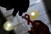 Two hands and HIV ribbon
